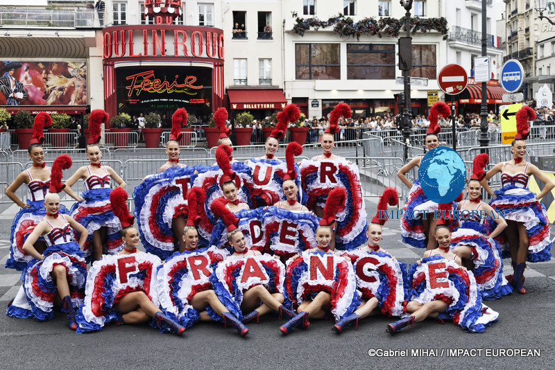 Moulin Rouge dancers perform with a Tour de France display in front of the iconic Paris cabaret.