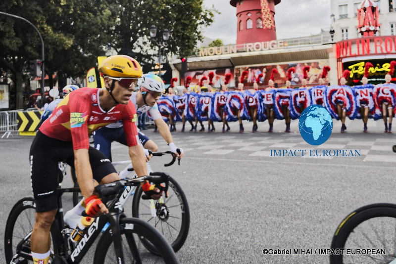 Leading Tour de France cyclists ride past the Moulin Rouge during the final stage in Paris.