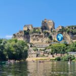 Canoes on the Dordogne below the medieval village and Château de Beynac in France