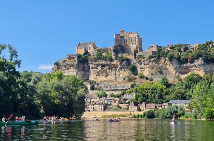 Canoes on the Dordogne below the medieval village and Château de Beynac in France